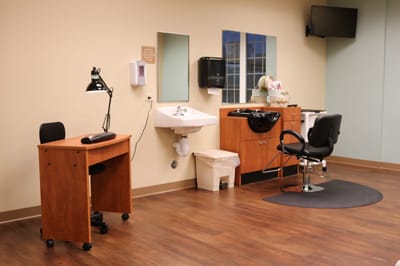Interior view of a salon setup with a chair, mirror, and sink