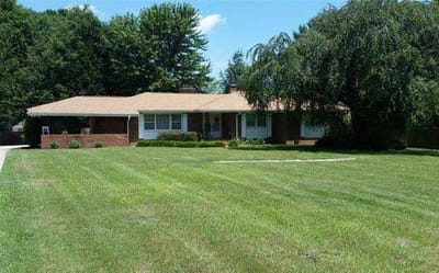 Exterior view of a single-story care home with a lawn