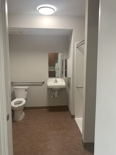 Bright and clean resident bathroom in a facility room