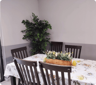 Cozy dining area with a floral tablecloth and greenery