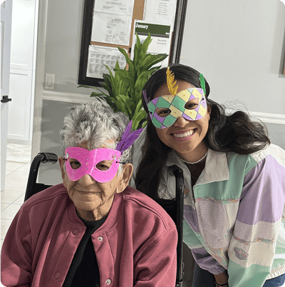 Residents and staff celebrating with masks at an indoor event