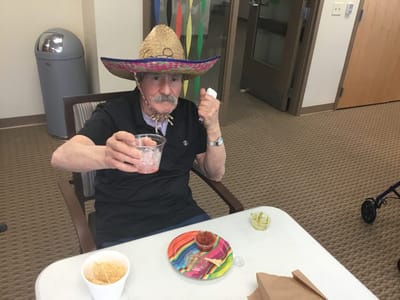 Resident enjoying a festive meal wearing a sombrero