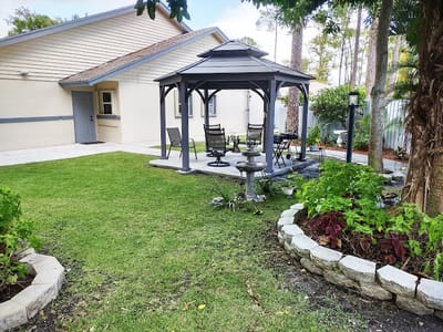 Outdoor gazebo area with seating and gardens