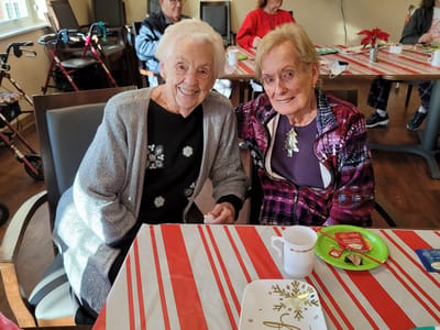 Two residents enjoying refreshments at a social gathering