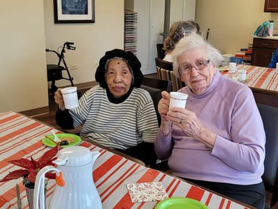 Two residents enjoying coffee in a common area