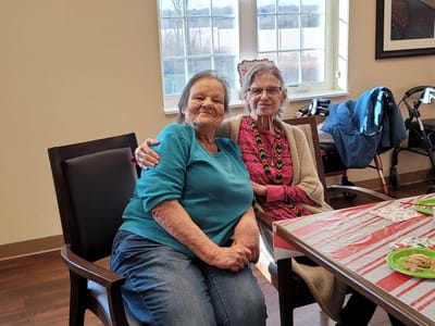 Two residents enjoying cookies and conversation in a common area