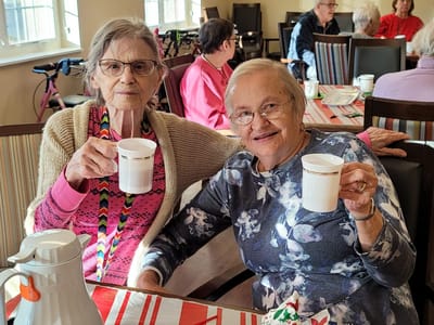 Two residents enjoying coffee in a common area