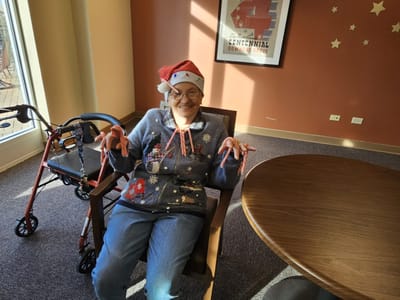 Resident wearing a festive outfit and Santa hat