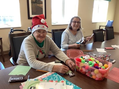 Residents engaged in a crafting activity at a dining table