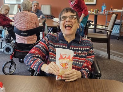 Resident enjoying popcorn in a cheerful common area