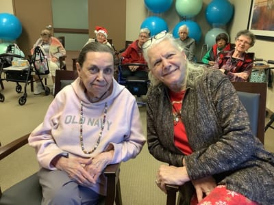 Two residents smiling together in a common area