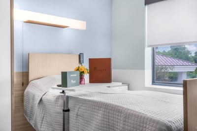 A cozy resident room with a bed and flowers