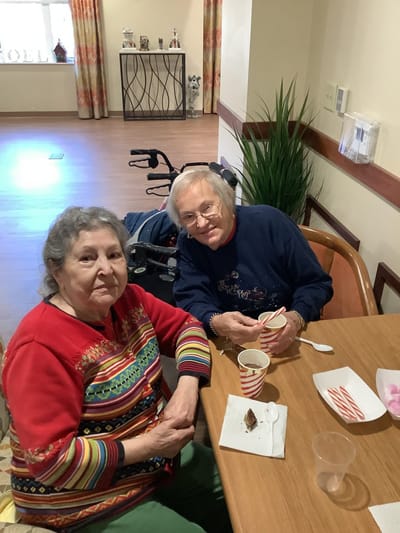 Two residents enjoying refreshments in a cozy common area