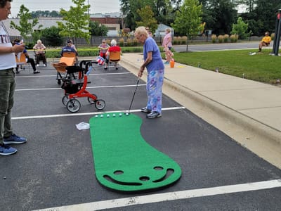 Resident playing mini-golf in the facility parking lot