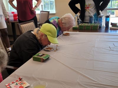 Residents enjoying a cookie-eating contest in a common area