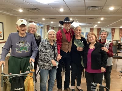 Residents posing with a performer in a common area