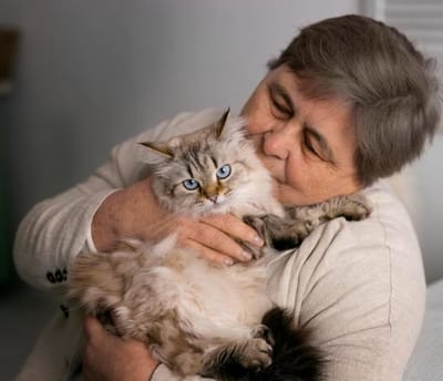 Resident cuddling a cat in a cozy setting