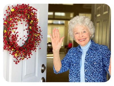 A senior woman smiles and waves by the door