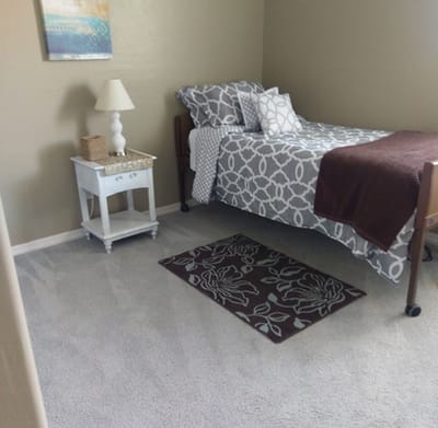 Cozy resident room with a bed and bedside table