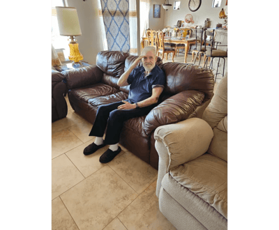Resident sitting on a couch in a communal area