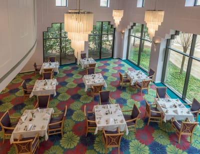 Brightly decorated dining room with tables set for meals.