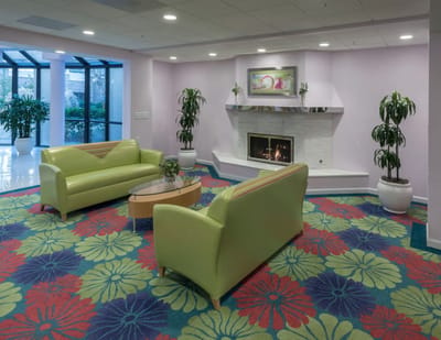 Cozy lounge with green sofas and a fireplace