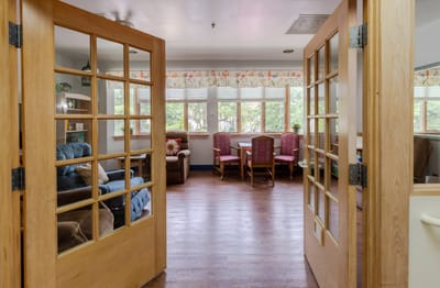 View of a cozy living room with seating and a dining area.