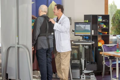 Staff assisting a resident with therapy equipment