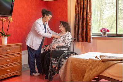 Caregiver assisting a resident in a cozy room
