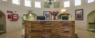 Reception area with stone counter and floral arrangement