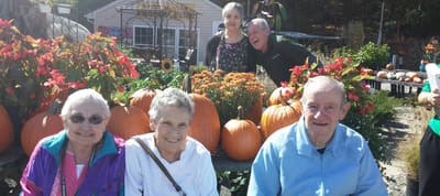 Residents enjoying a fall outdoor gathering with pumpkins