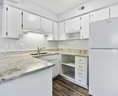 Modern kitchen space with white cabinetry and granite countertops
