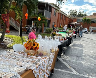 Residents enjoying an outdoor food event with tables and decorations