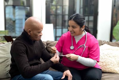 Nurse assisting a senior resident in a cozy interior