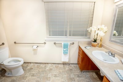 Well-lit bathroom with safety features for residents