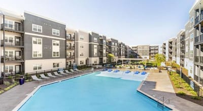 Outdoor pool area with apartment buildings nearby