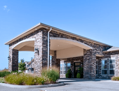 Front entrance of a senior living facility with stone architecture