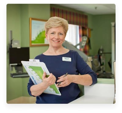 Staff member holding a clipboard in a facility lobby