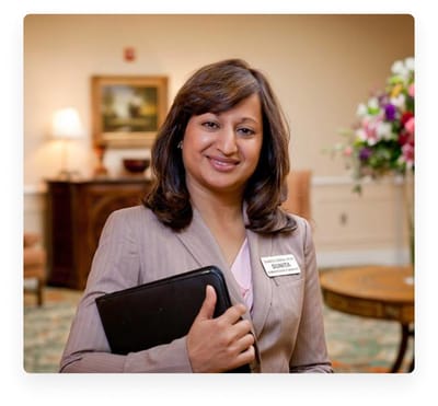 A staff member smiling in a welcoming interior space