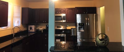 Modern kitchen area with dark wood cabinets