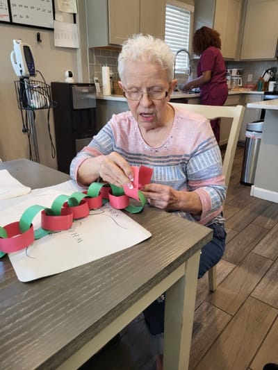 A resident making paper chains in an activity room