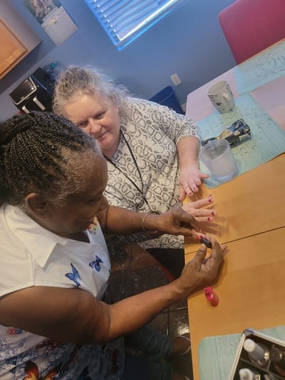 Staff and resident enjoying a nail painting activity