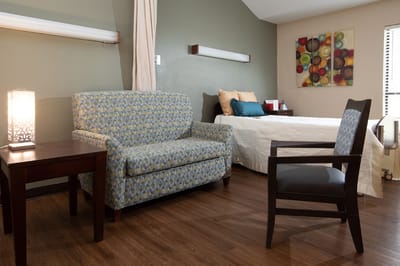 A cozy resident room with a couch and bed