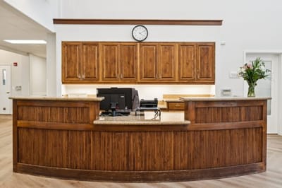 Reception area with a wooden front desk and flowers
