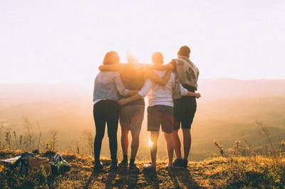Four people enjoying a sunset outdoors.