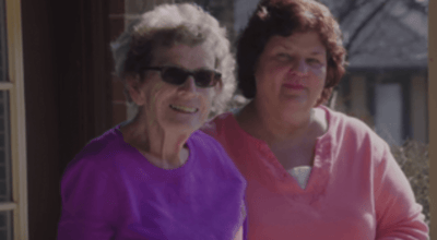 Two women smiling outdoors at a facility.