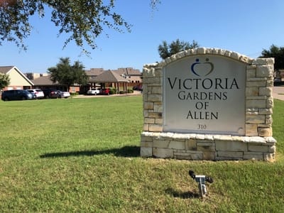 Sign for Victoria Gardens of Allen in a landscaped yard