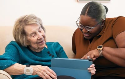 A caregiver and a resident enjoying time together with a tablet