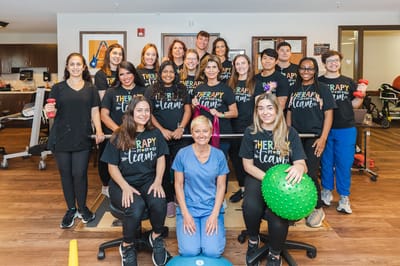 Therapy team posing in a rehabilitation center activity room