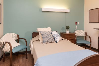 Cozy resident room with a bed and chairs